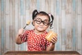 Little asian girl holding and enjoying peanut butter in jar and a spoon