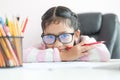 Little Asian girl holding the pencil to doing homework and smile with happiness for education concept select focus shallow depth Royalty Free Stock Photo