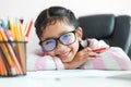 Little Asian girl holding the pencil to doing homework and smile with happiness for education concept select focus shallow depth Royalty Free Stock Photo