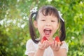 Girl holding strawberries and smiles between picnic