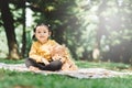 Little asian girl hugging her teddy bear in a park. Royalty Free Stock Photo