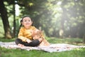 Little asian girl hugging her teddy bear in a park. Royalty Free Stock Photo