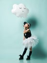 Little asian girl kid in fashion skirt hold metallic sleeping cloud balloon for kids birthday and send a kiss on blue mint