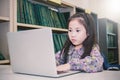 Little asian girl with laptop playing computer games Royalty Free Stock Photo