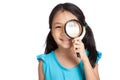Little asian girl with magnifying glass