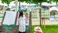 Little Asian girl painting on board with stick outdoors in park. Happy childhood and creativity Royalty Free Stock Photo