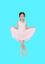 Little asian girl in pink leotard practise her ballet dance isolated on cyan background. Children is studying ballet Royalty Free Stock Photo