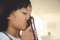 Little Asian girl praying with holding the cross, Christian concept Royalty Free Stock Photo