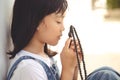 Little Asian girl praying with holding the cross, Christian concept