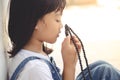 Little Asian girl praying with holding the cross, Christian concept Royalty Free Stock Photo