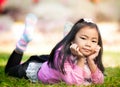 Little asian girl resting on green grass Royalty Free Stock Photo