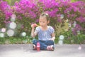 Girl sitting and blowing bubles in park