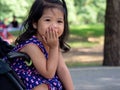 Little asian girl sitting in a stroller at public park. She have be smile and love in sign language Royalty Free Stock Photo