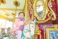 Girl smiling while riding a horse in merry-go-round Royalty Free Stock Photo