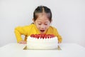 Little asian girl with strawberry cake. Kid with happy birthday cake on the table Royalty Free Stock Photo
