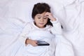 Little asian girl using smartphone and lying on the bed Royalty Free Stock Photo