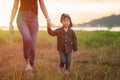 Little asian girl walking in the nature with her mom, Mother holding hands of her daughter. Children walk to explore nature for Royalty Free Stock Photo