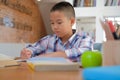 little asian kid boy schoolboy writing drawing on notebook. child children doing homework. Royalty Free Stock Photo