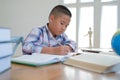 little asian kid boy schoolboy writing drawing on notebook. child children doing homework. Royalty Free Stock Photo