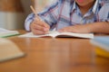 little asian kid boy schoolboy writing drawing on notebook. child children doing homework. Royalty Free Stock Photo