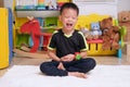 Little Asian kid with eyes closed, barefoot practices yoga, meditating to relieve negative emotions