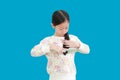 Little asian little kid girl combing long hair isolated on blue background with clipping path. Hair care concept Royalty Free Stock Photo