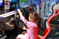 Little Asian kid girl playing arcade video game. Racing car Royalty Free Stock Photo