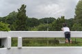 Little asian kids stand on the bridge, leaning on the fence