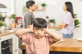 Little asian sad boy, unhappy while parents fighting, kid son not listen to shouting noise while mom and dad arguing, quarrel Royalty Free Stock Photo