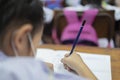 Little asian school girl writing notebook homework with pencil Royalty Free Stock Photo