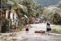 Little Asian school girls walking to school on a muddy road in a jungle conditions in Port Barton Palawan the Philippines