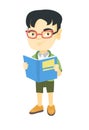 Little asian schoolboy reading a book.