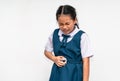 Little Asian student girl is stomach ache, unidentified school uniform, isolated portrait of Asian child girl with stomach pain on