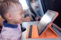 Little Asian 1 year old toddler boy coloring in coloring book with crayons during flight on airplane Royalty Free Stock Photo