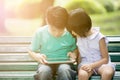 Little Asianboy and girl are playing together with a computer ta