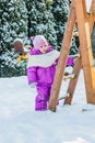 Little babe girl playing on the winter playground. Royalty Free Stock Photo