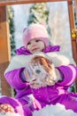 Little babe girl playing on the winter playground. Royalty Free Stock Photo