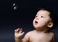 Little baby asian boy drooling and looking soap bubble Royalty Free Stock Photo