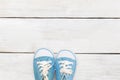 Little baby blue sneakers on a white wooden background Royalty Free Stock Photo