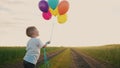 little baby boy with balloons. happy family a birthday kid dream concept. baby son holding balloons against a blue sky Royalty Free Stock Photo