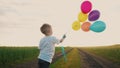 little baby boy with balloons. happy family a birthday kid dream concept. baby son holding balloons against a blue sky Royalty Free Stock Photo