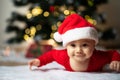 Little baby boy in a christmas outfit lying on a soft fur in front of a christmas tree Royalty Free Stock Photo