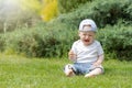 Little baby boy is crying sitting on the grass Royalty Free Stock Photo