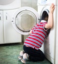 Little baby boy dangerously putting his head into washing machine drum Royalty Free Stock Photo