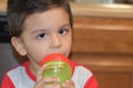 Toddler drinking on his bottle at his home`s kitchen. Royalty Free Stock Photo