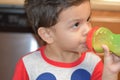 Toddler drinking on his bottle at his home`s kitchen. Royalty Free Stock Photo