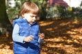 Little baby boy eating biscuit or cookies in autumn park Royalty Free Stock Photo