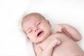 Little baby boy girl crying on white. Newborn baby less than a year with clenched fists Royalty Free Stock Photo