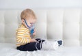 Little baby boy himself using steam inhaler nebulizer mask himself on the bed. copy space. health medical care.