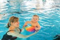 Little baby boy and his mother learning to swim in an indoor swimming pool Royalty Free Stock Photo